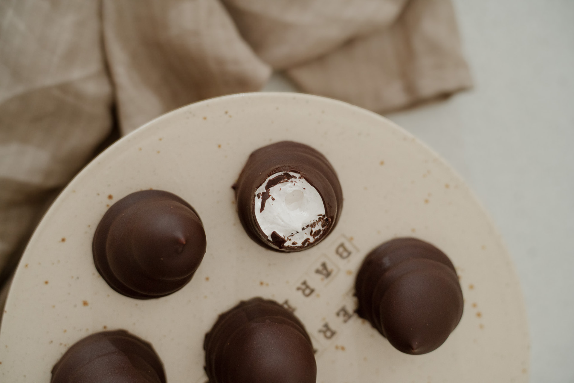 Hjemmelavede flødeboller med mørk chokolade på en lys tallerken
