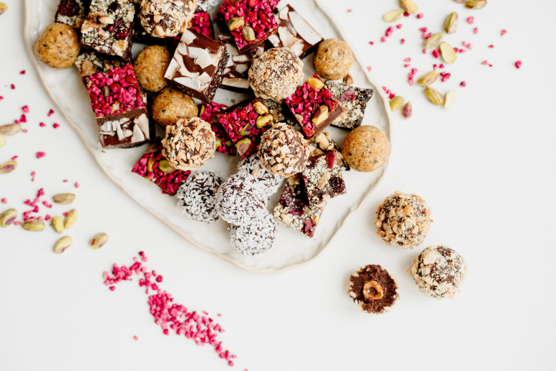 En tallerken fyldt med farverige fredagssnacks, konfekt og nødder set fra oven