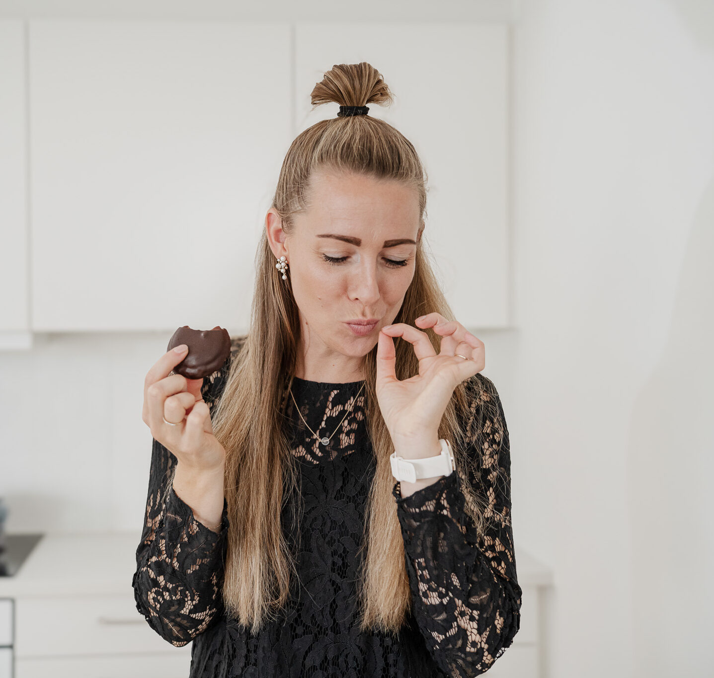 Nicole smager på en chokoladekage og slikker sig om munden i køkkenet